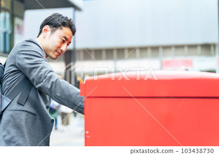 man posting mail in mailbox man posting mail in mailbox 103438730