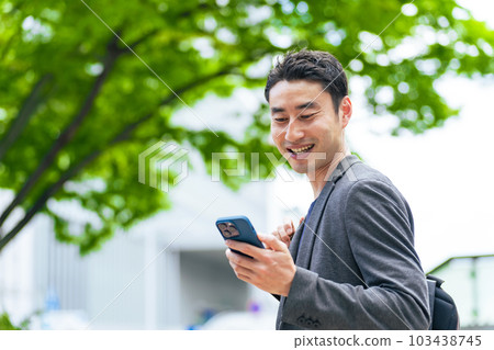 A man using a smartphone in the city A man using a smartphone in the city 103438745