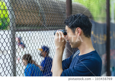 Man watching a sports game with binoculars Man watching a sports game with binoculars 103438769
