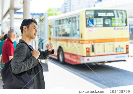 man waiting for bus at bus stop 103438799