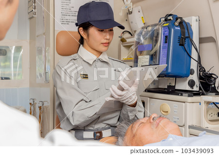 Paramedics checking pulse in ambulance 103439093