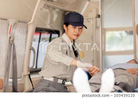 Paramedics checking pulse in ambulance 103439110