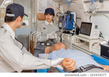 Paramedics checking pulse in ambulance 103439377