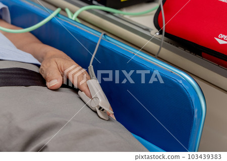 Patient wearing a pulse oximeter in an ambulance 103439383