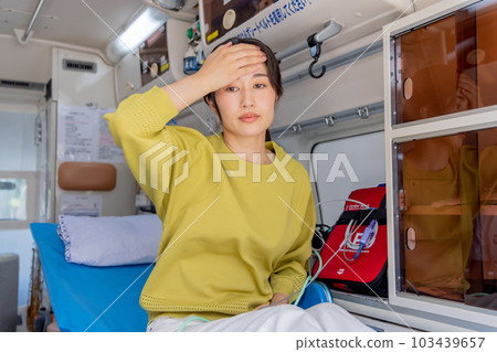 Young woman regaining consciousness in an ambulance 103439657