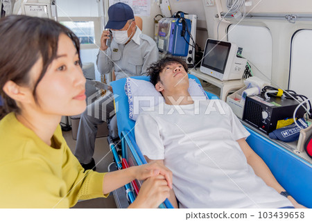 Young man being carried by ambulance 103439658