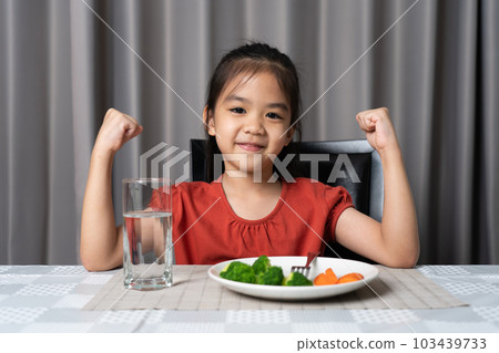 Kid shows strength of eats vegetables and nutritious food. Kid shows strength of eats vegetables and nutritious food. 103439733