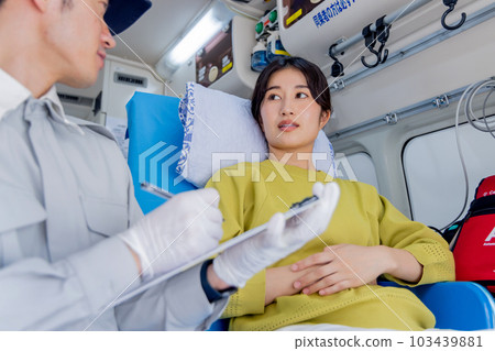 An ambulance worker asking a question to an unwell woman who called an ambulance 103439881