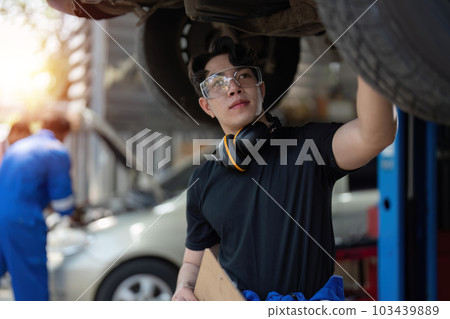 car mechanic car suspension detail of lifted automobile at repair service station 103439889