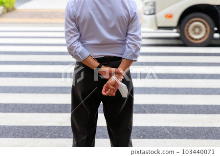 穿過人行橫道時摘下口罩並拿在手裡的人 103440071
