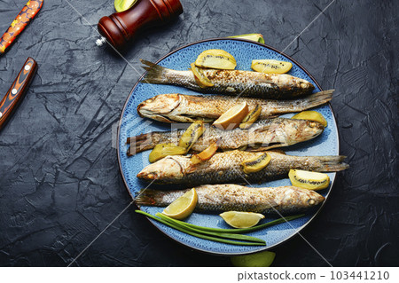 Fried whole fish with kiwi and lime. 103441210