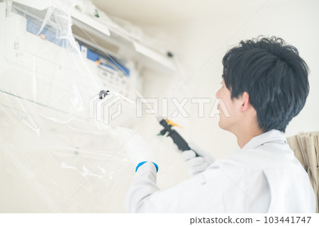 Male staff cleaning the air conditioner Male staff cleaning the air conditioner 103441747