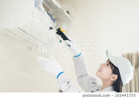 Female contractor staff cleaning air conditioner Female contractor staff cleaning air conditioner 103441755