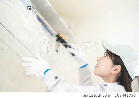 Female contractor staff cleaning air conditioner Female contractor staff cleaning air conditioner 103441756