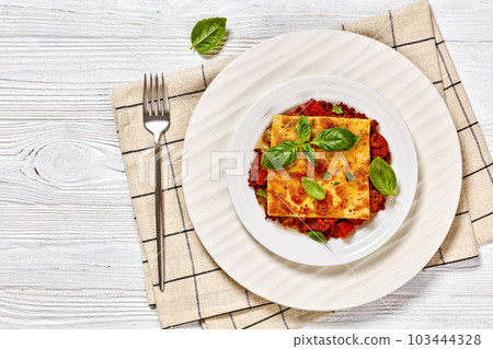 portion of upside down pizza on white plate 103444328