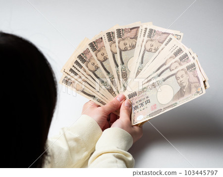 女人的手拿著很多錢 103445797