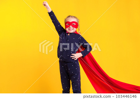 Funny little power superhero child (girl) in a red raincoat and a mask. Superhero concept. 103446146