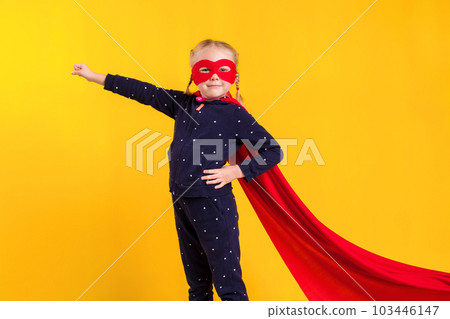 Funny little power superhero child (girl) in a red raincoat and a mask. Superhero concept. Funny little power superhero child (girl) in a red raincoat and a mask. Superhero concept. 103446147