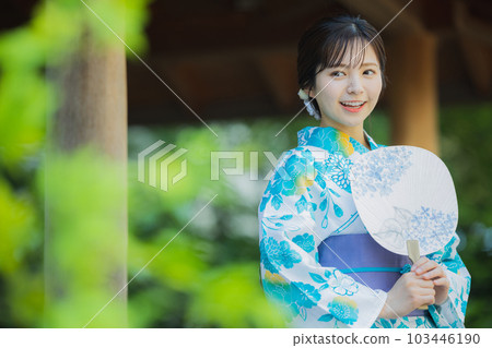 A woman in a yukata walking outdoors 103446190