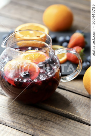 A glass pot filled with herbal tea with plenty of fresh fruit A glass pot filled with herbal tea with plenty of fresh fruit 103446789