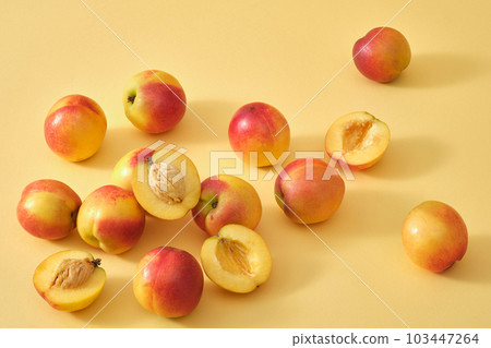 Top view of a lot of peaches are arranged against the beige background. Peach (Prunus persica) contains a rich source of vitamins to help brighten and smooth skin 103447264
