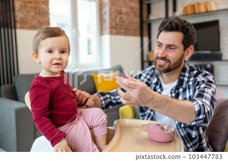 First child lure. Father feeding his cute little baby daughter. First child lure. Father feeding his cute little baby daughter. 103447783