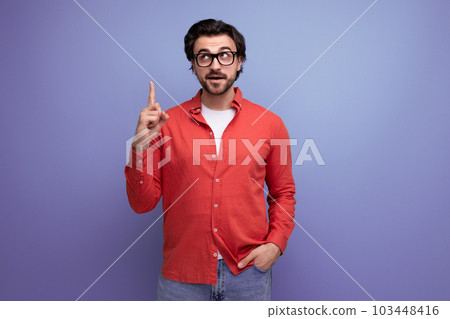 smart handsome young brunette man in glasses and a red shirt on the background with copy space smart handsome young brunette man in glasses and a red shirt on the background with copy space 103448416