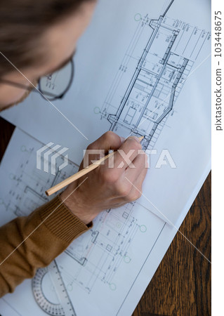 Architect drawing blueprint sketching design of house, making architectural construction building. Architect drawing blueprint sketching design of house, making architectural construction building. 103448675