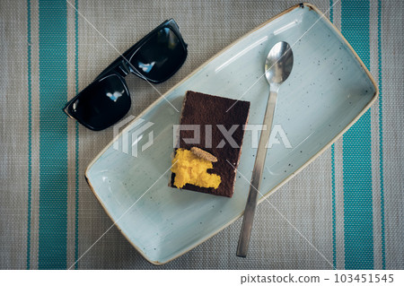 shot of top view of tiramisu and sunglasses shot of top view of tiramisu and sunglasses 103451545