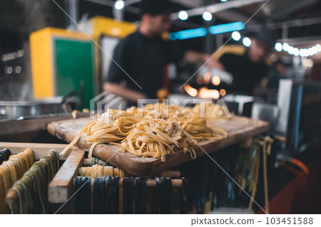 traditional italian black and yellow raw pasta on food festival 103451588
