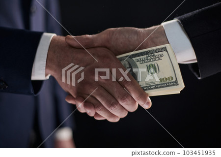 Handshake with the transfer of money on a black background Handshake with the transfer of money on a black background 103451935
