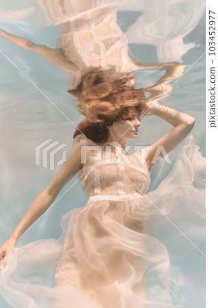 Portrait of a woman underwater in a lacy white dress in light colors Portrait of a woman underwater in a lacy white dress in light colors 103452977