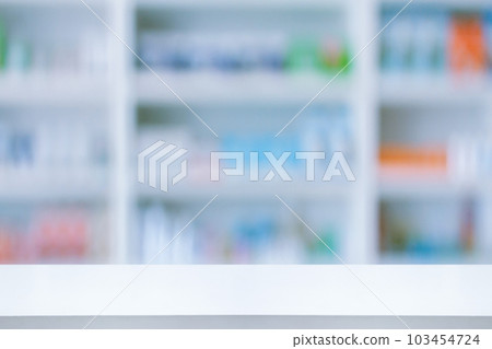 Empty white counter with pharmacy drugstore shelves blurred background Empty white counter with pharmacy drugstore shelves blurred background 103454724