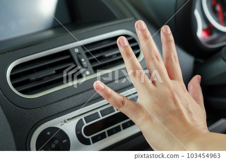 hand checking air conditioner system inside the car 103454963