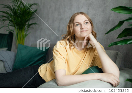 Young dreaming woman thinking about a future travel, resting in a hotel room alone, enjoying, planning future 103455255