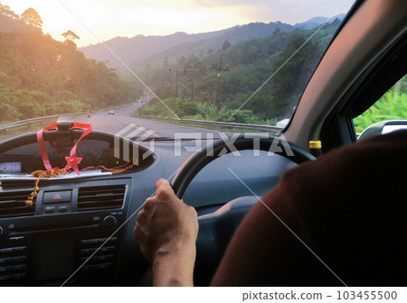 Hand driving a car on the road blurred background Hand driving a car on the road blurred background 103455500