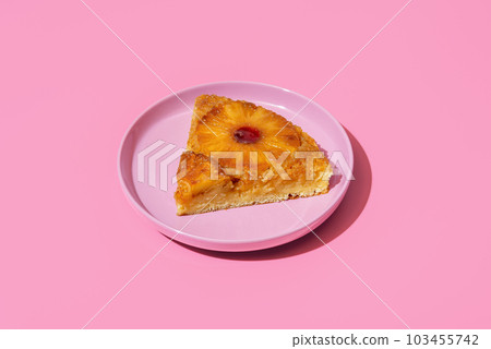 Pineapple cake slice on a plate isolated on a pink background Pineapple cake slice on a plate isolated on a pink background 103455742