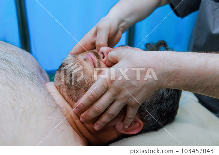 Manual therapist specializes in anti-aging face massages to improve skins elasticity reduce signs of aging. 103457043
