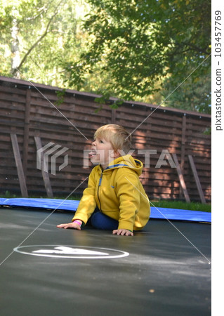 A boy on a trampoline in the garden. . High quality photo A boy on a trampoline in the garden. . High quality photo 103457769