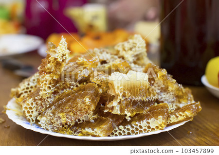 Honey with honeycombs on a plate Honey with honeycombs on a plate 103457899