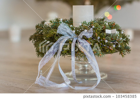 Advent wreath of twigs with candle and various ornaments Advent wreath of twigs with candle and various ornaments 103458385