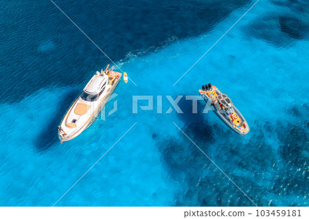 Aerial view of luxury yachts and boats on blue sea at sunset Aerial view of luxury yachts and boats on blue sea at sunset 103459181