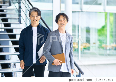 Two businessmen (plain clothes) having a meeting in the aisle 103459305