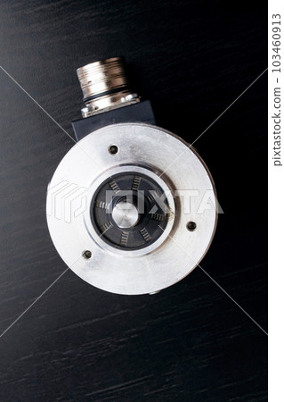 Metal encoder on a black wooden table Metal encoder on a black wooden table 103460913