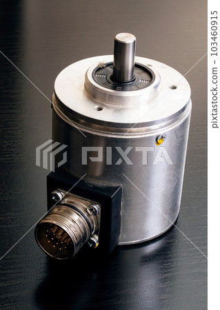Metal encoder on a black wooden table Metal encoder on a black wooden table 103460915