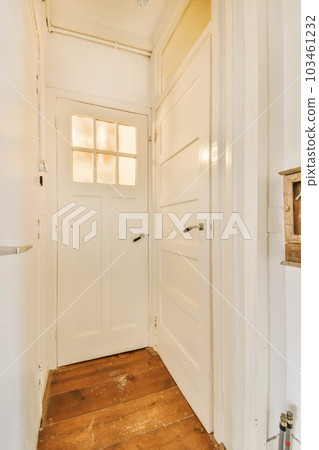 the inside of a room with wood flooring and white door leading to an open doorway that leads to another room 103461232