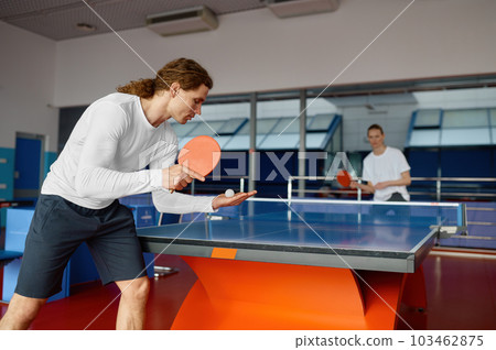 Man and woman playing table tennis, focus on sportsman player serving 103462875