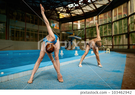 Young female fitness instructor training adult sportsman at swimming pool 103462942