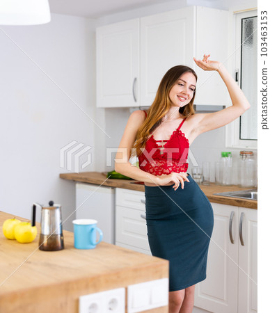 Happy woman dancing in the kitchen at home 103463153