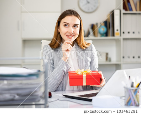 Young woman office worker with gift box 103463281